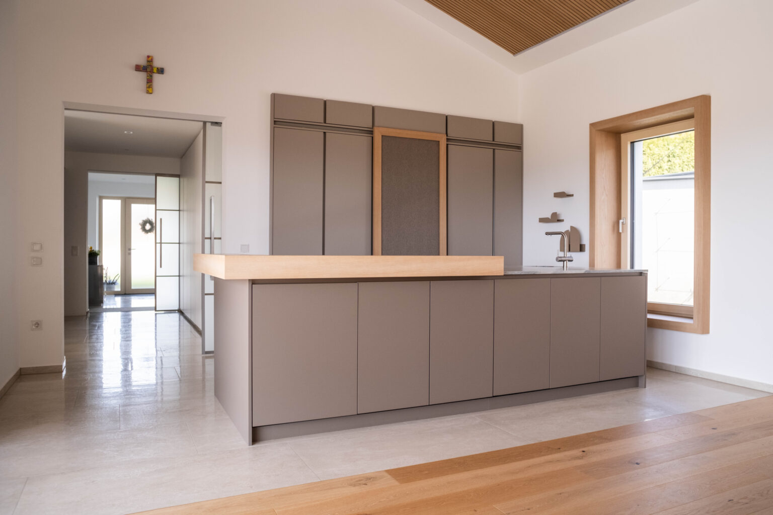 Graue Kücheninsel mit Eichenplatte im Wohnraum mit Holzdecke