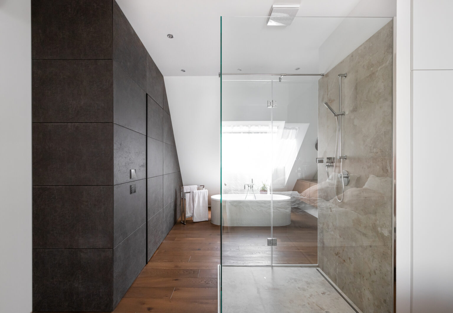 Badezimmer mit dunklen Einbauschränken und Glasdusche