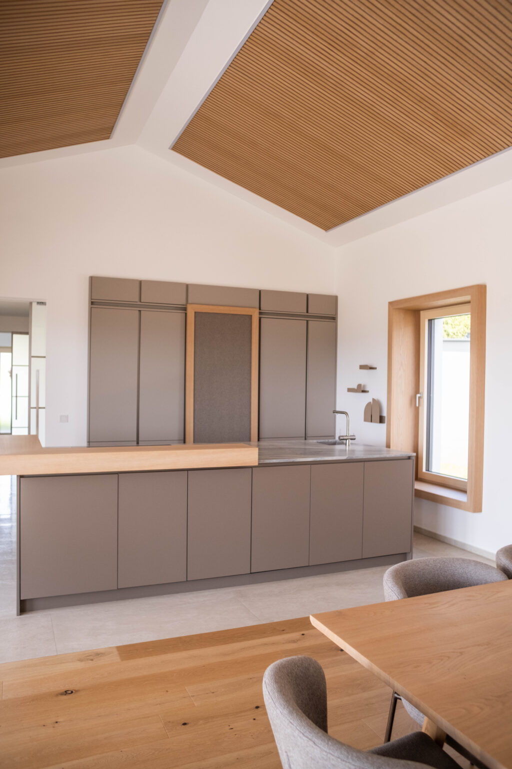 Küche mit grauen Fronten unter einer Holzdecke