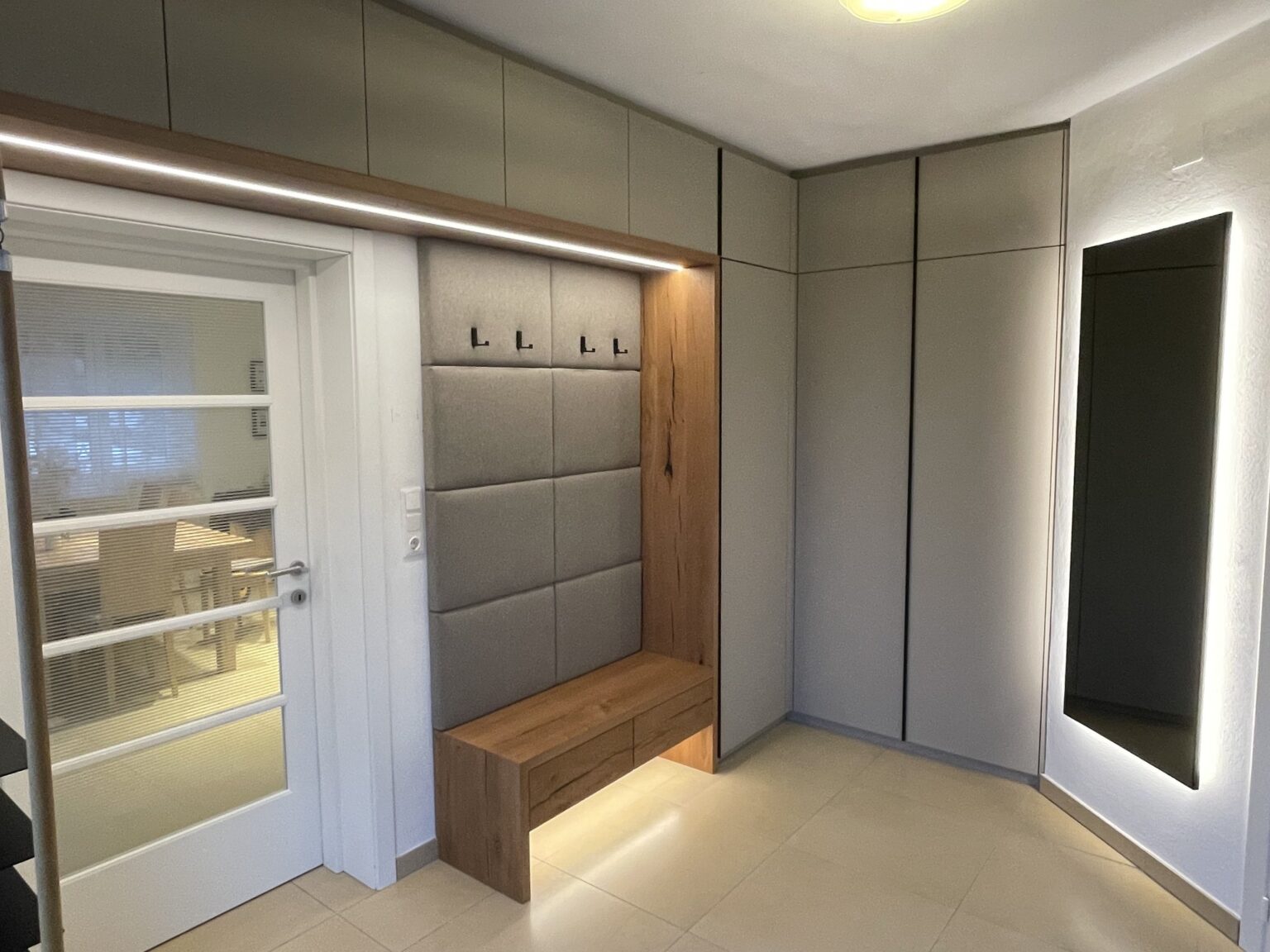 Garderobe mit gepolsterter Wand, Sitzbank und Leuchtspiegel